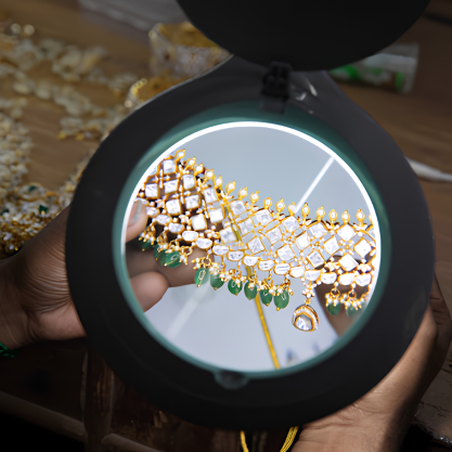 Jeweller inspecting a traditional gold necklace with a magnifying glass