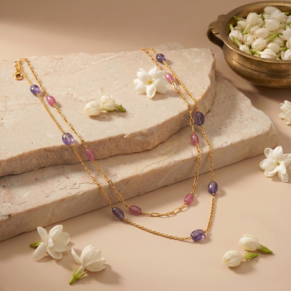Silver necklace with purple and pink beads on a stone slab.