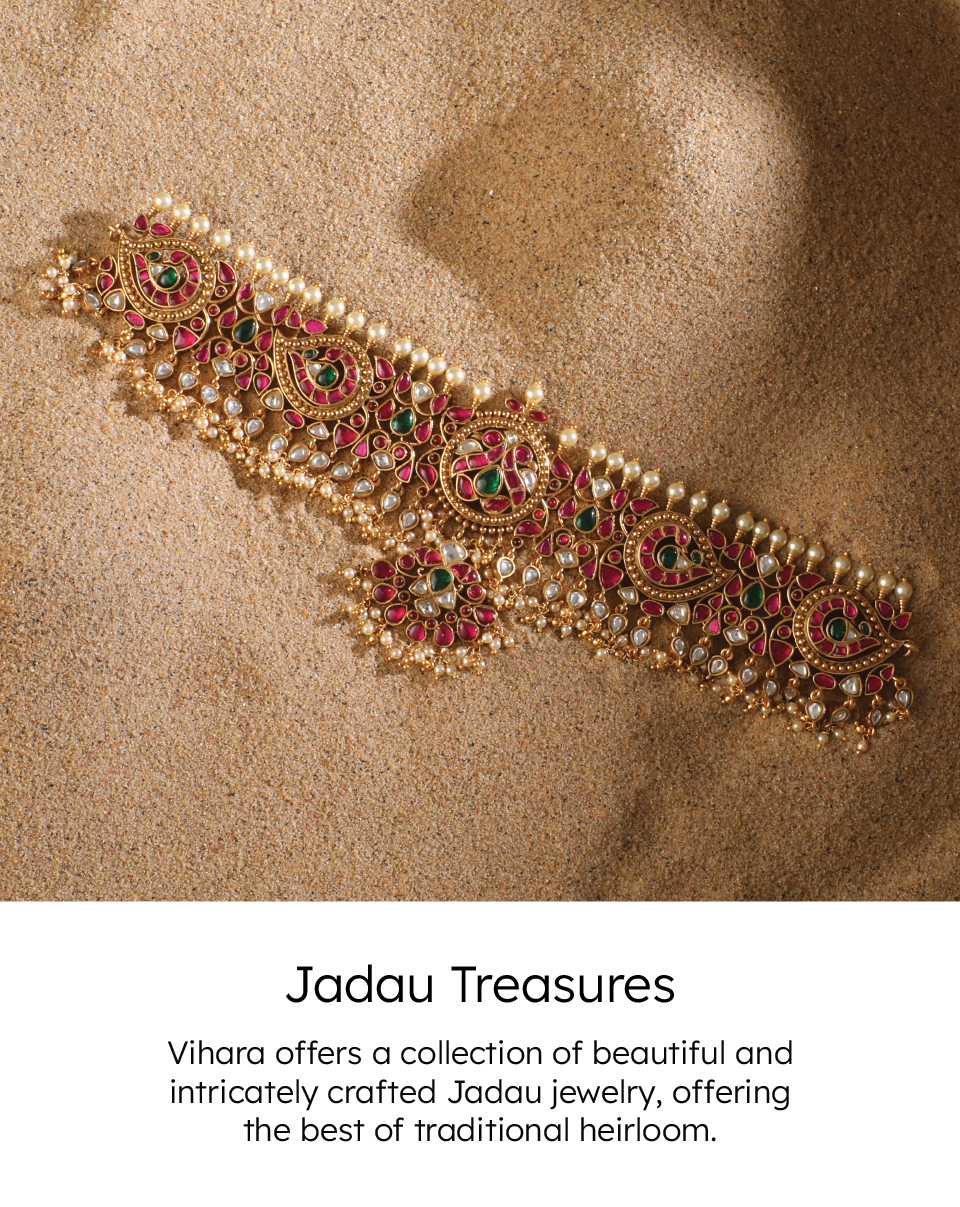 Ornate jadau jewelry pieces with gemstones and pearls, arranged on a velvet cloth in a way that highlights their beauty and delicacy.