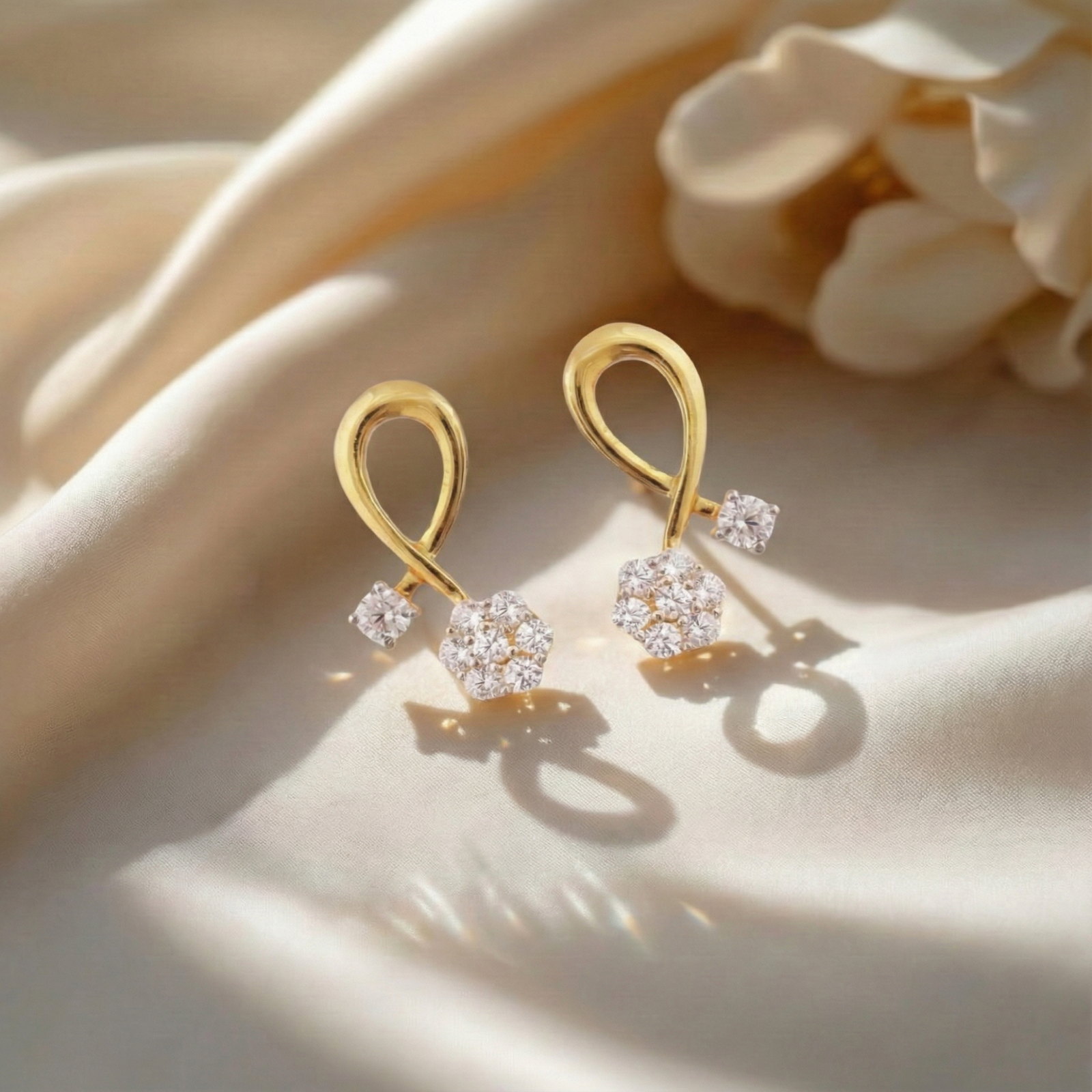 A picture of a pair of gold plated silver earrings with Cubic Zirconia on a white background.