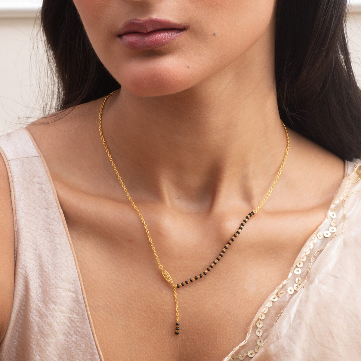 Gold-plated silver mangalsutra with black beads, worn