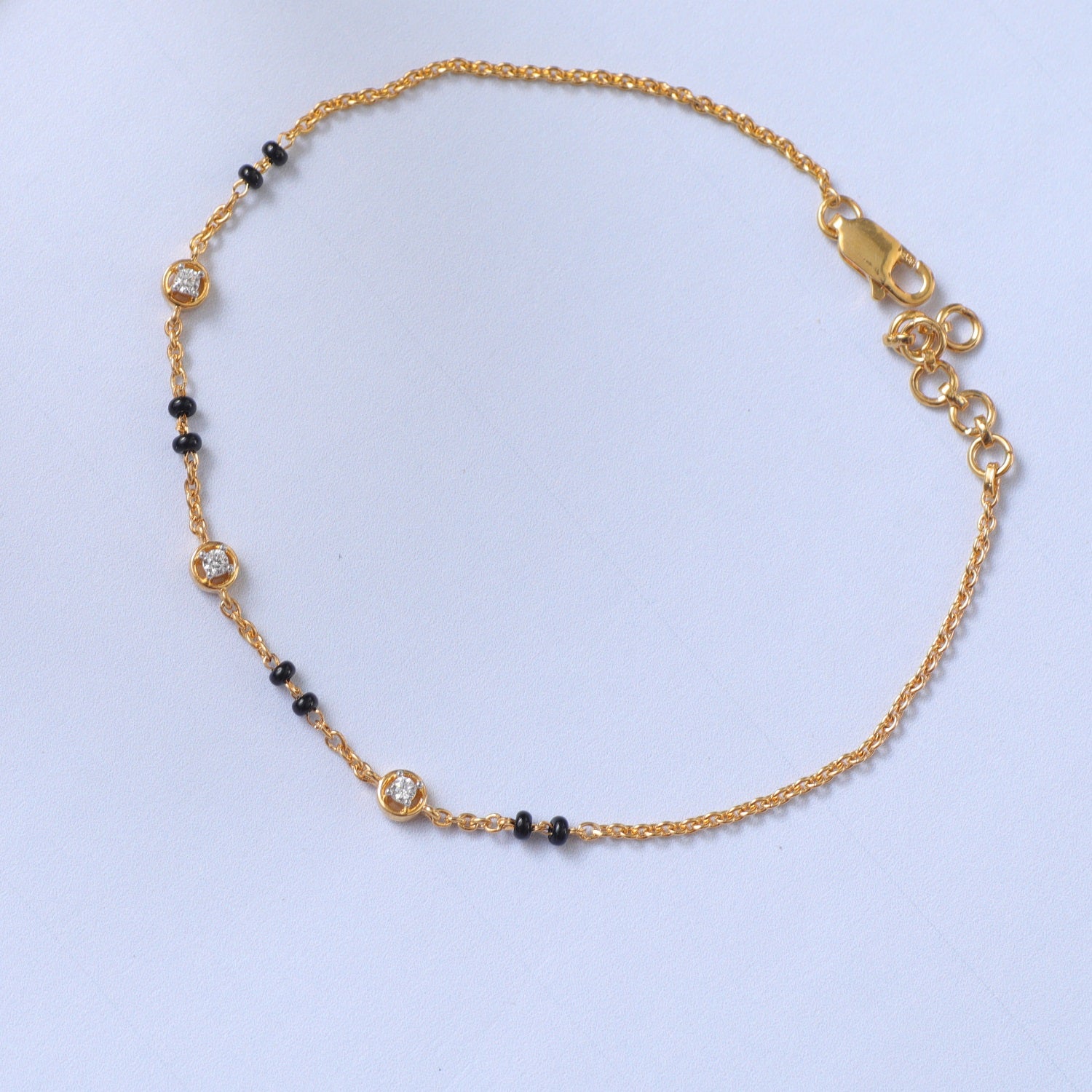 A picture of a silver bracelet with black beads and Cubic Zirconia on a white background.