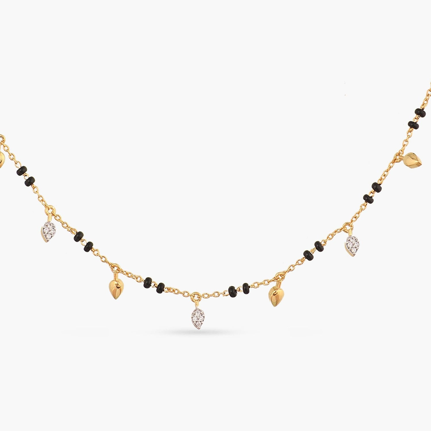 A picture of a gold plated necklace with black beads and heart-shaped charms featuring Cubic Zirconia on a white background.