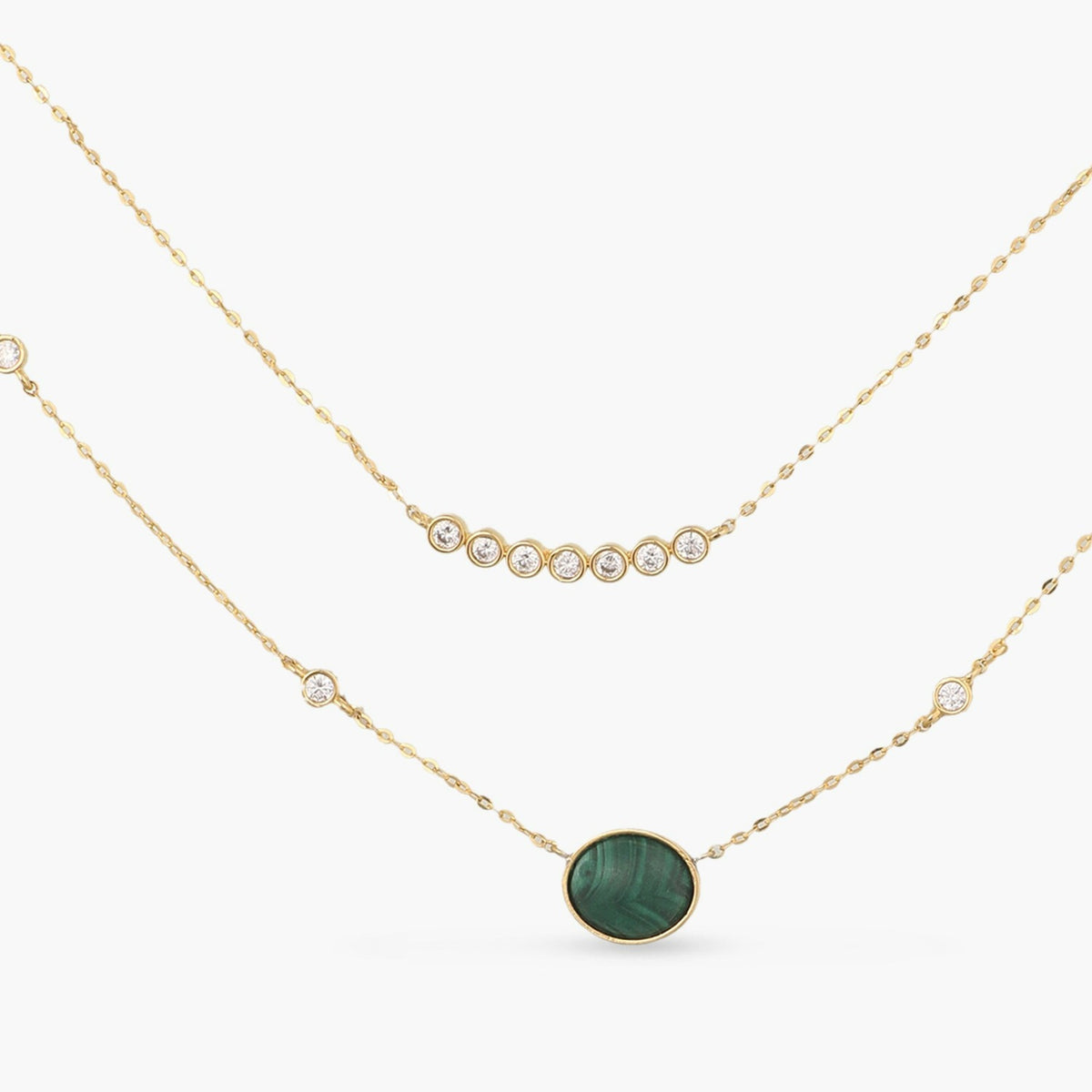 An image of a two layered silver necklace, featuring cubic zirconia and malachite stones.