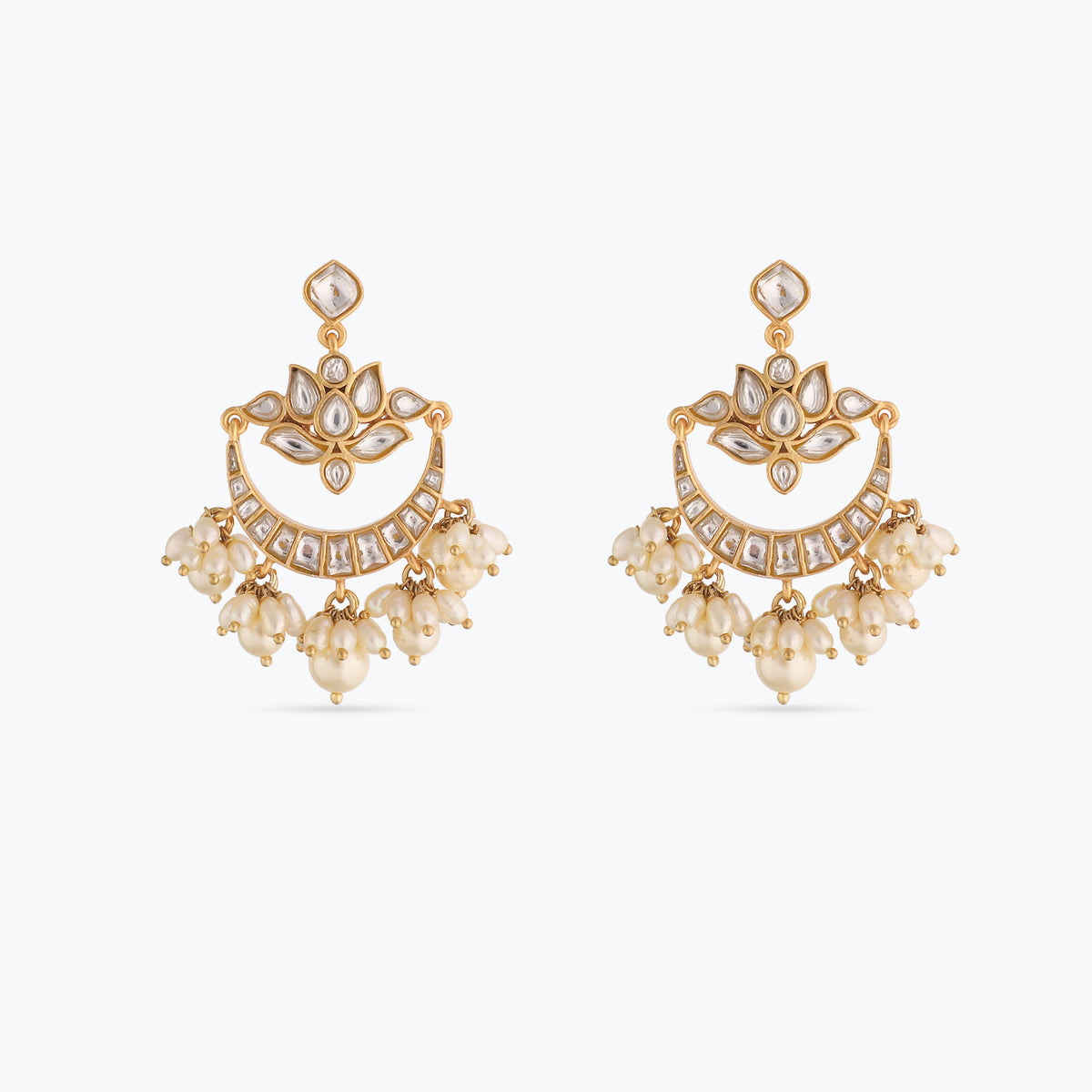 A picture of a pair of silver earrings set with Kempu and Jadau stones on a white background.