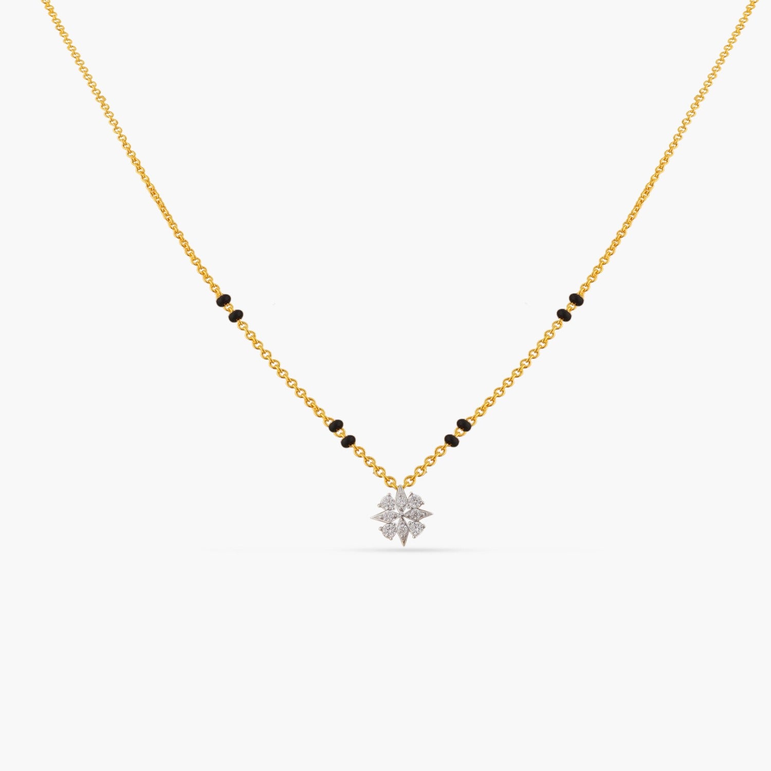 A picture of a gold plated silver chain with black beads and a flower pendant, featuring Cubic Zirconia on a white background. 